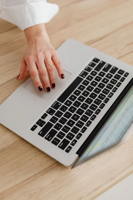 Une équipe variée travaille ensemble autour d’un bureau sur des stratégies de marketing numérique, avec des ordinateurs portables et des tablettes.